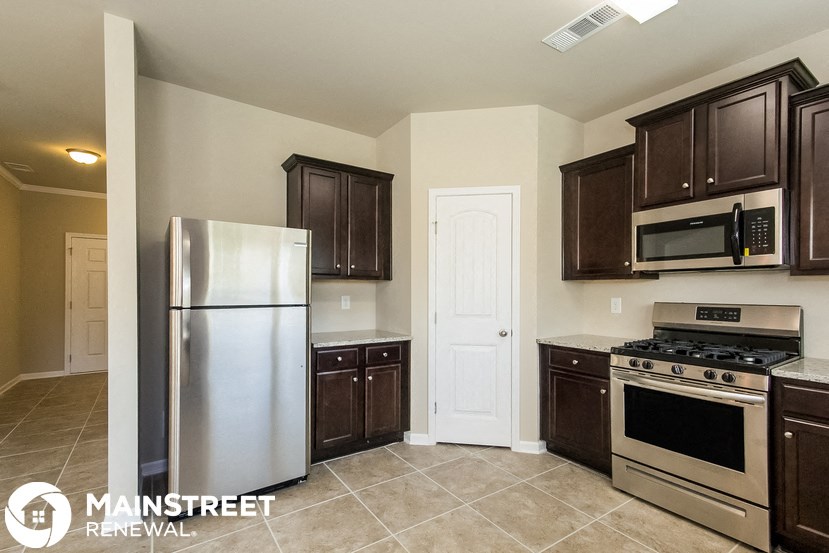 a kitchen with stainless steel appliances and wooden cabinets