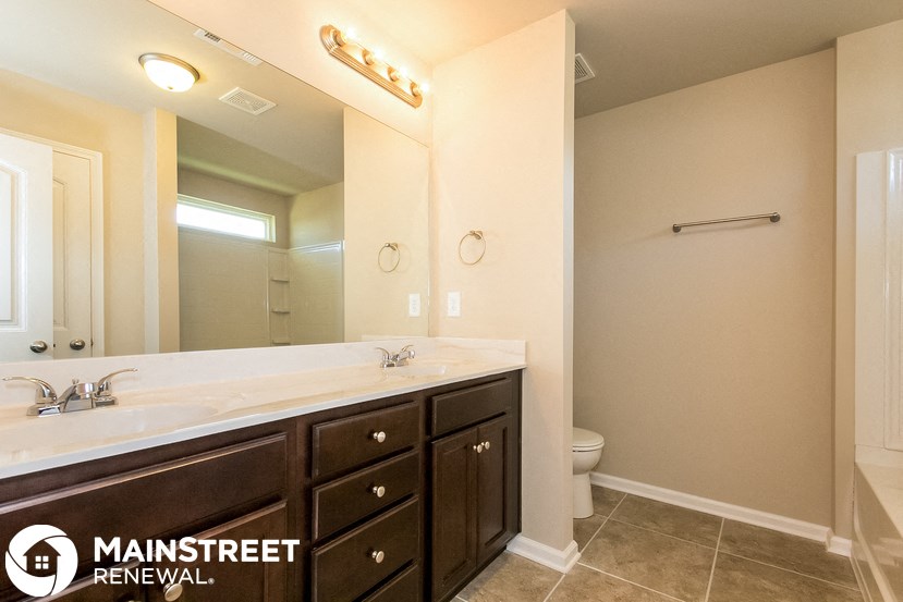 a bathroom with a large mirror and a sink and a toilet