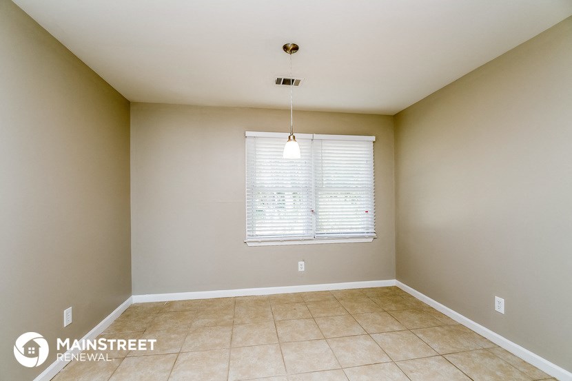 the spacious dining room has a large window and tile flooring