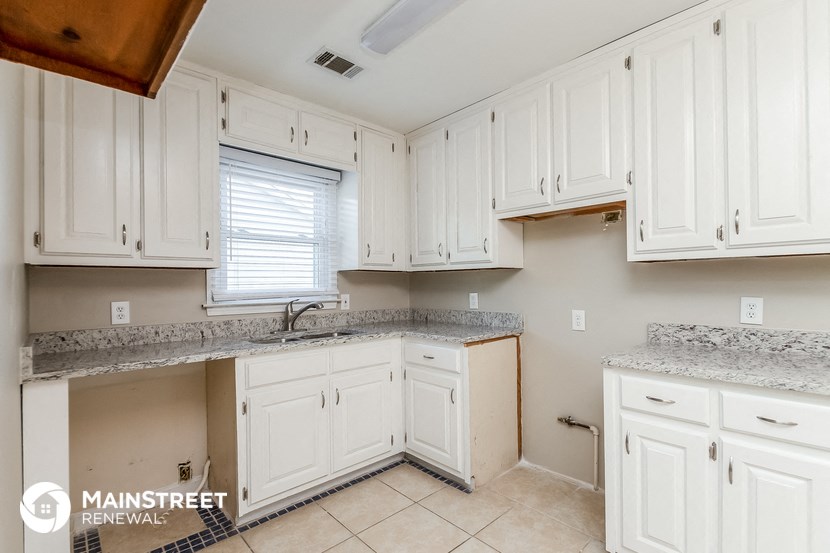 a white kitchen with white cabinets and white counter tops