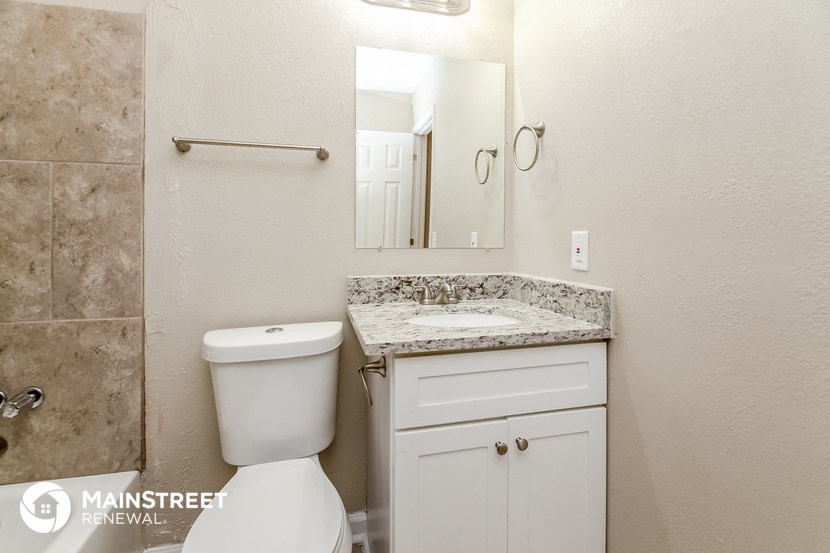 a bathroom with a toilet and a sink and a mirror