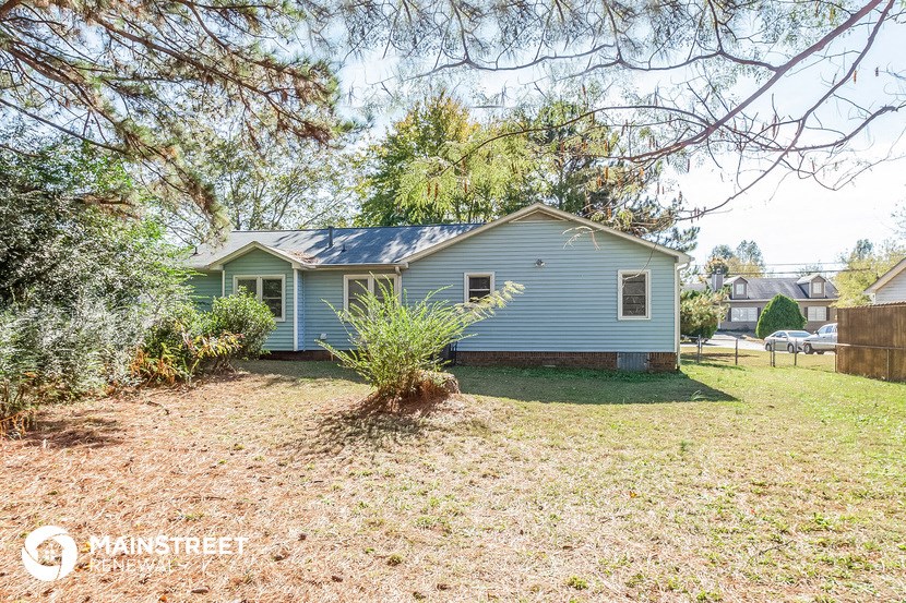 a blue house with a yard and a tree