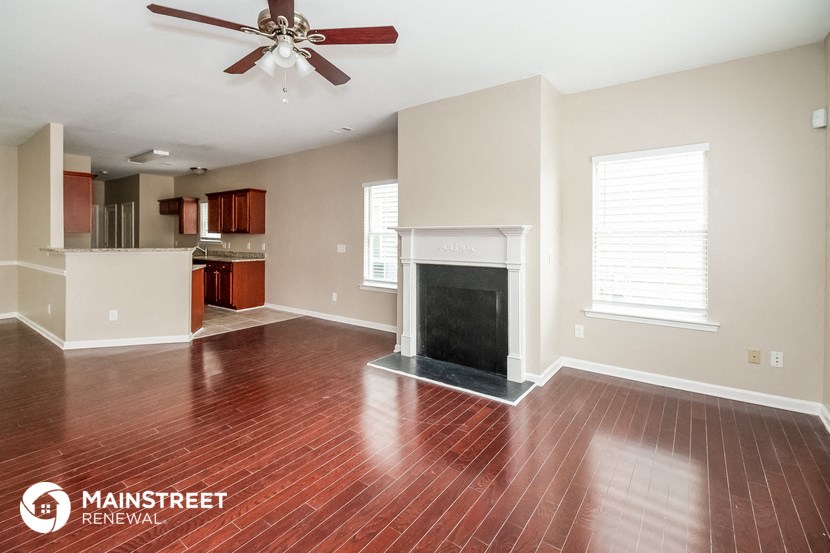 the living room and kitchen of an empty house with a fireplace
