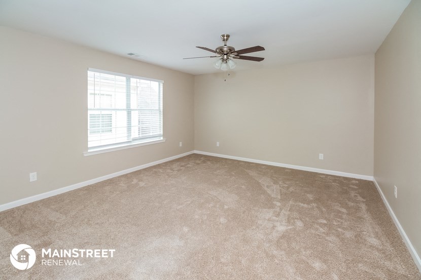 a bedroom with carpet and a ceiling fan