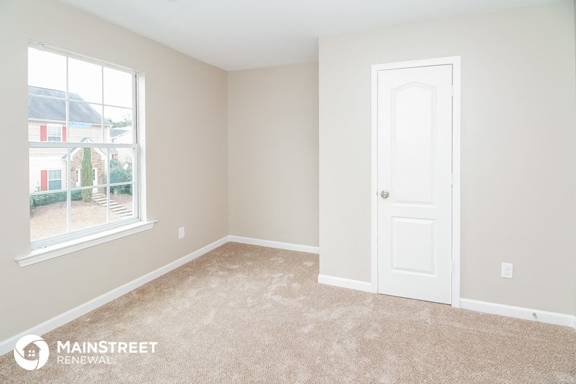 a bedroom with a white door and a window