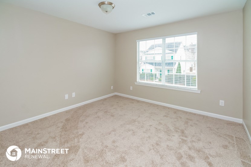 a bedroom with carpeted floors and a large window