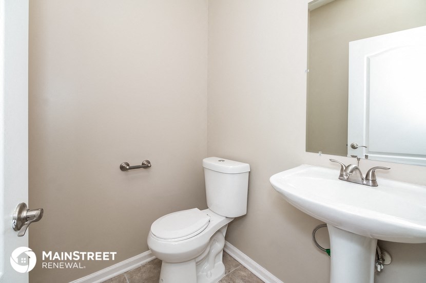 a bathroom with a toilet and a sink and a mirror