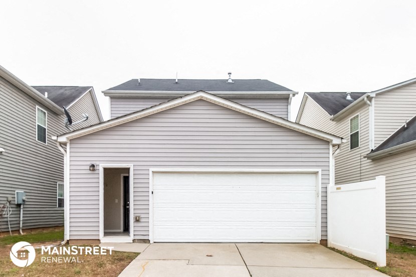 the front of a white garage with a white door