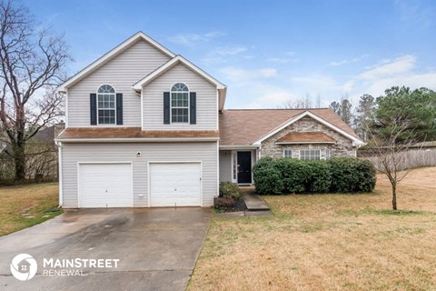 a white house with a white garage and a brown roof