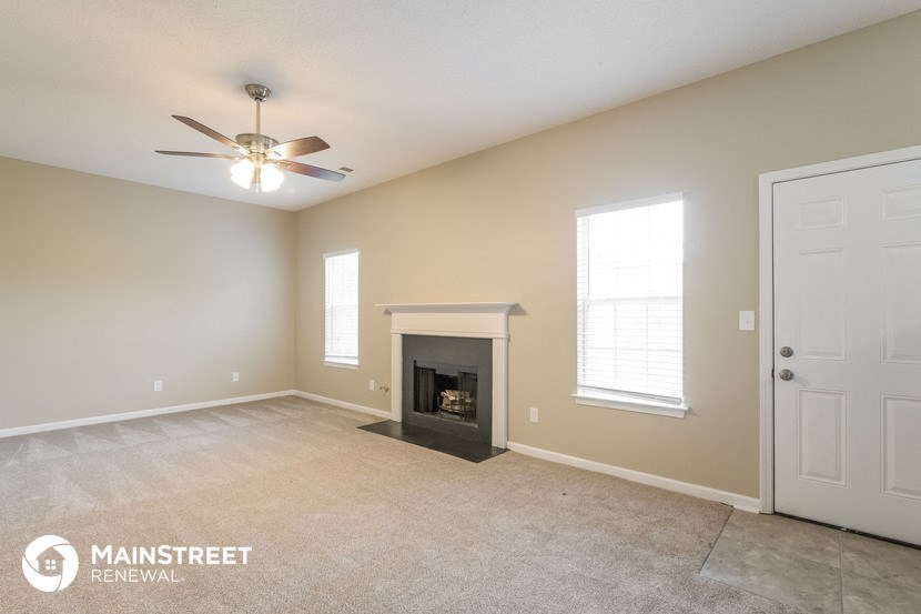 the living room with fireplace and ceiling fan
