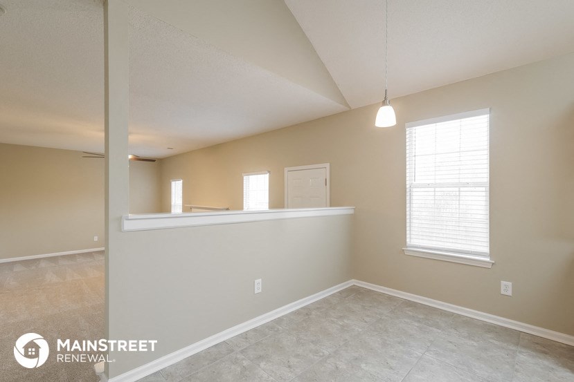 the spacious living room and dining room with a large window