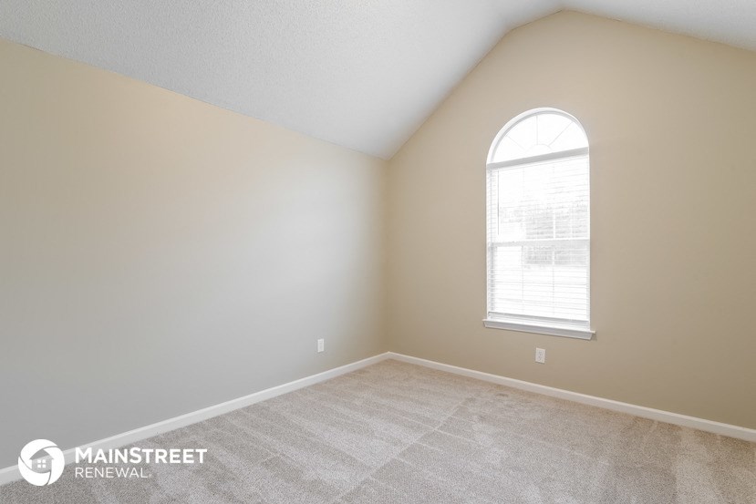 the upstairs bedroom with carpet and a large window