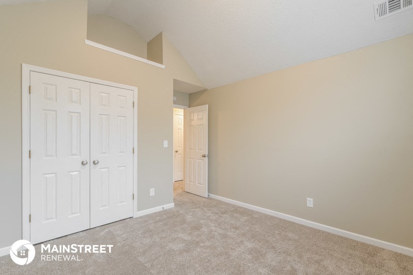 a bedroom with two closets and a door to a hallway
