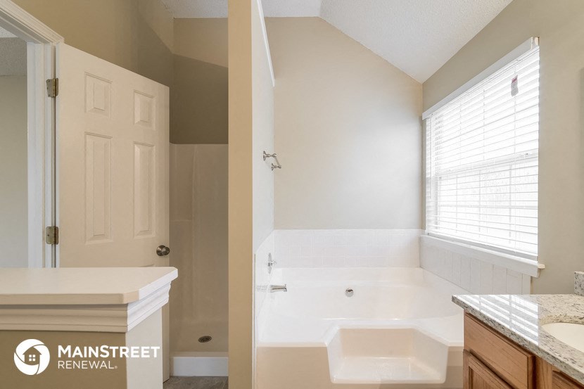 a bathroom with a tub and a sink and a window