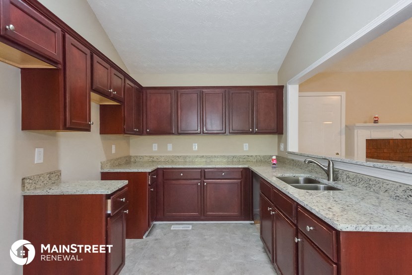 a kitchen with wood cabinets and granite counter tops and a sink
