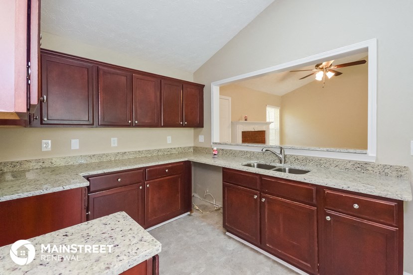 a kitchen with wooden cabinets and granite counter tops and a sink
