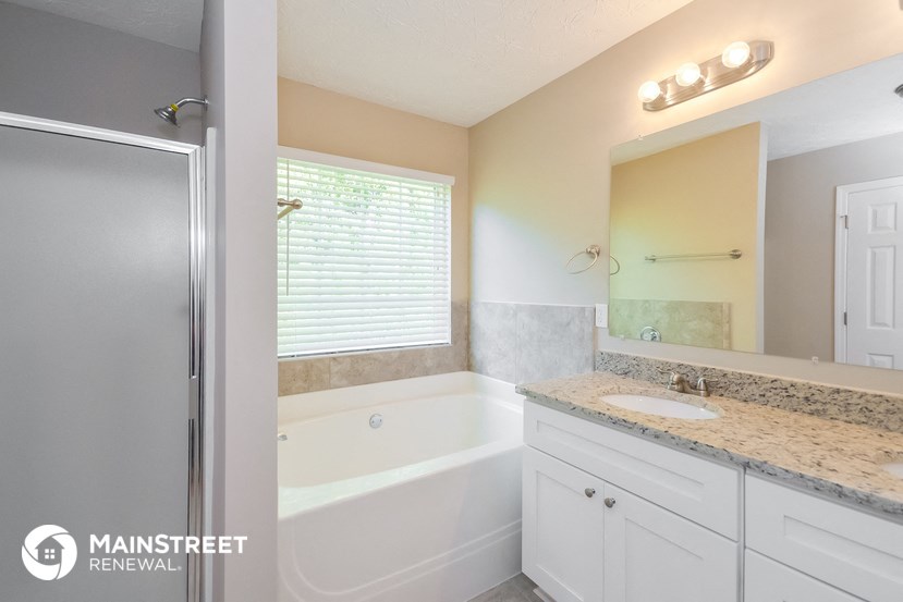a bathroom with a tub and a sink and a mirror