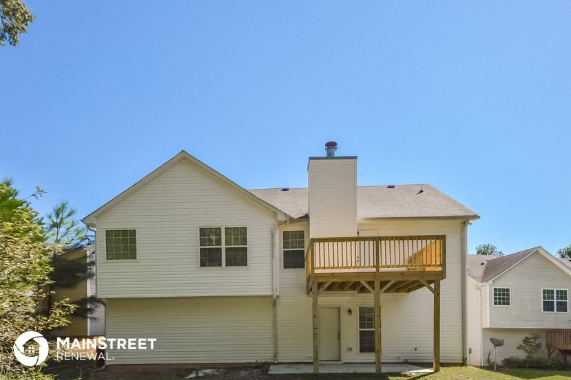 a white house with a deck and a blue sky