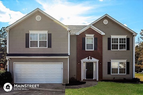 a tan and brown house with a white garage door