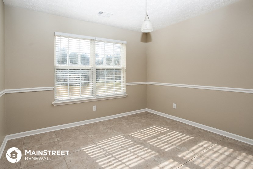 a empty room with a large window and a carpeted floor
