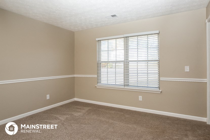 a room with a window and a carpeted floor