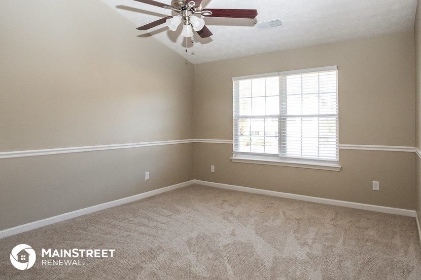 an empty room with a ceiling fan and a window