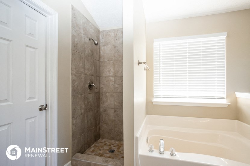 a bathroom with a tub and a shower and a window