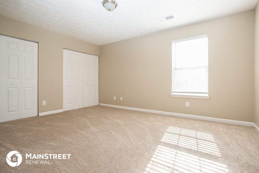 an empty room with two doors and a window