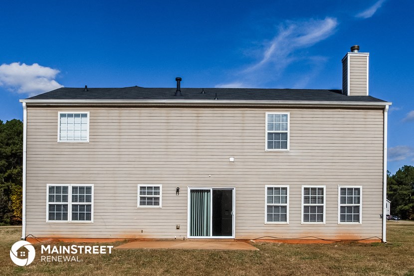 a white house with a green door and a blue sky