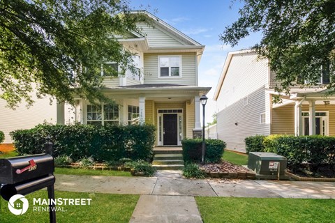 a small yellow house with a sidewalk in front of it
