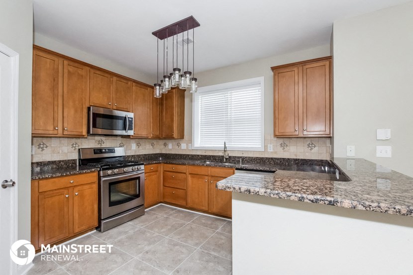 a kitchen with granite counter tops and wooden cabinets