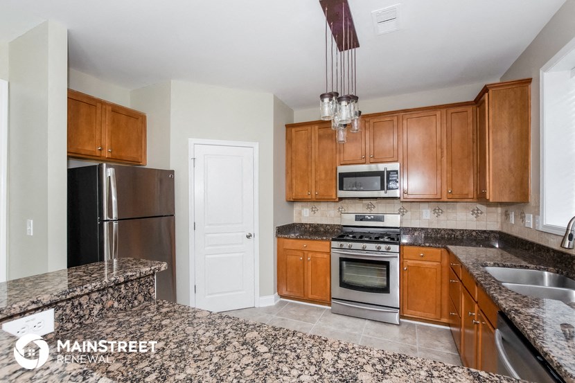 a kitchen with granite counter tops and wooden cabinets