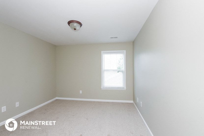 the upstairs bedroom with carpet and a window