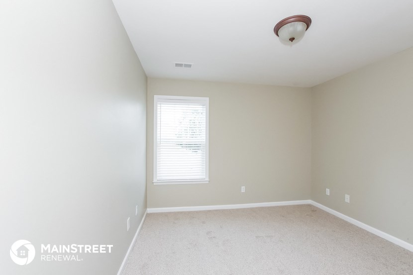 an empty room with white carpet and a window