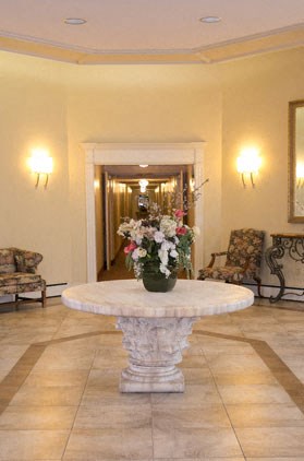 a lobby with a table with a vase of flowers on it