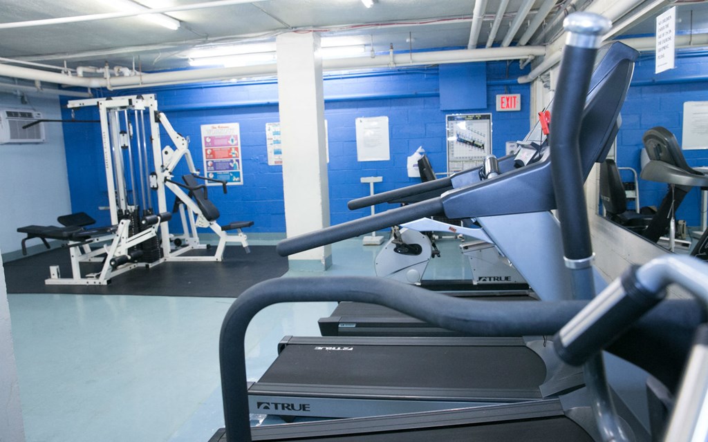 a gym with cardio equipment and weights in a prison