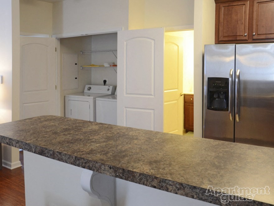 a kitchen with a granite counter top and a stainless steel refrigerator