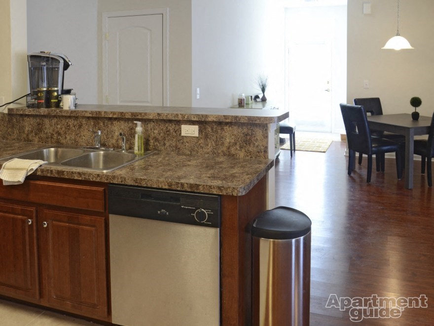 a kitchen with a counter top and a dishwasher and a dining room