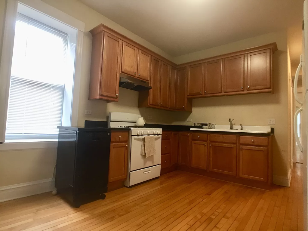an empty kitchen with wooden floors and wooden cabinets