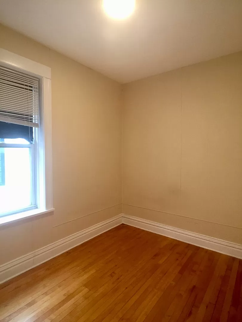 an empty room with wooden floors and a window