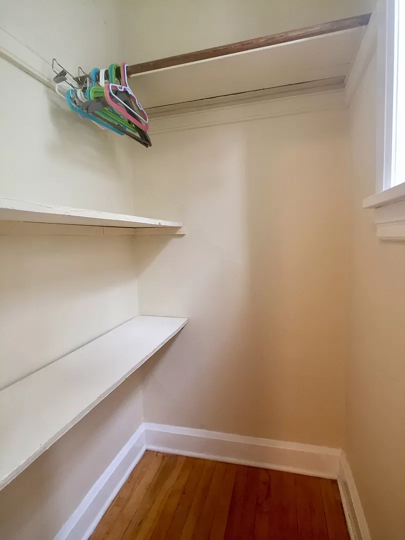 a walk in closet with a shoe rack on the wall
