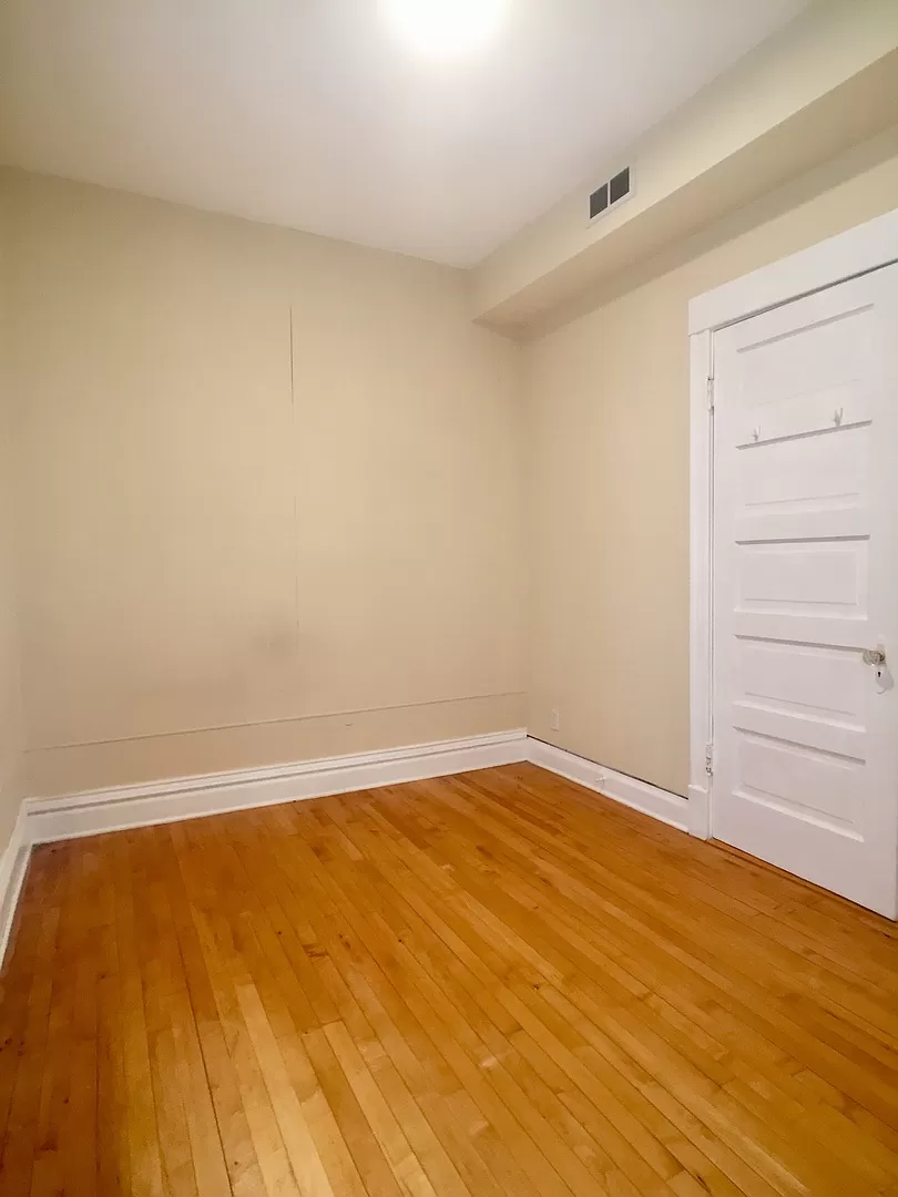 an empty room with a wooden floor and a white door