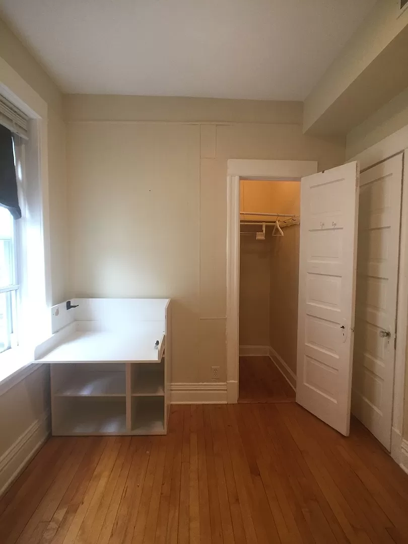 an empty room with a desk and a closet