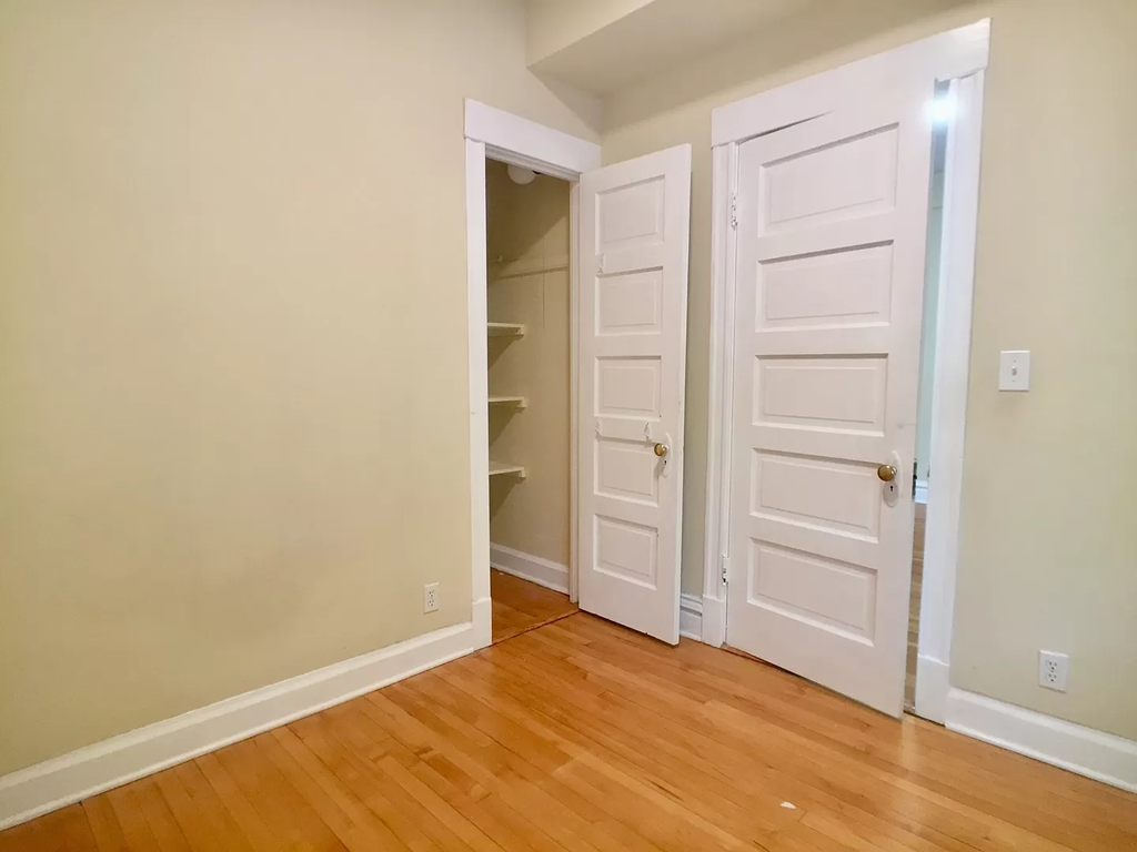 a room with two closets and a wooden floor