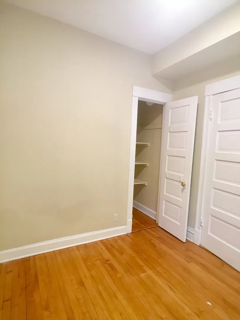 an empty room with wooden floors and a closet