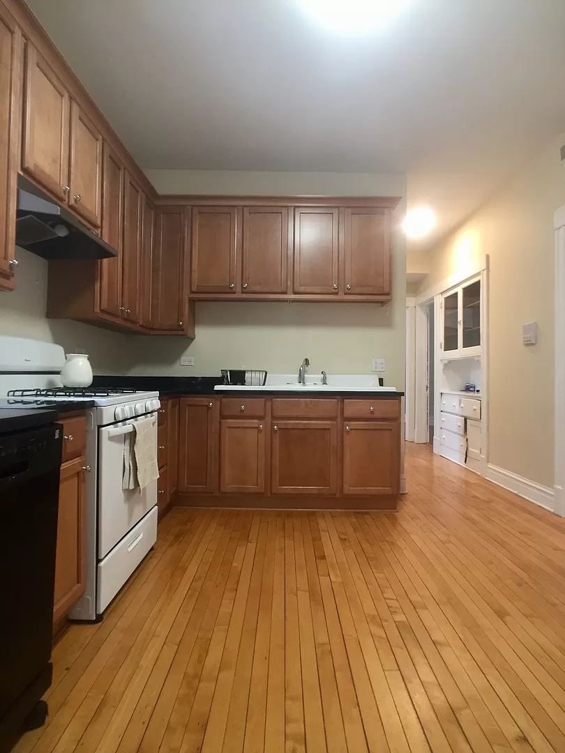 an empty kitchen with wooden floors and wooden cabinets
