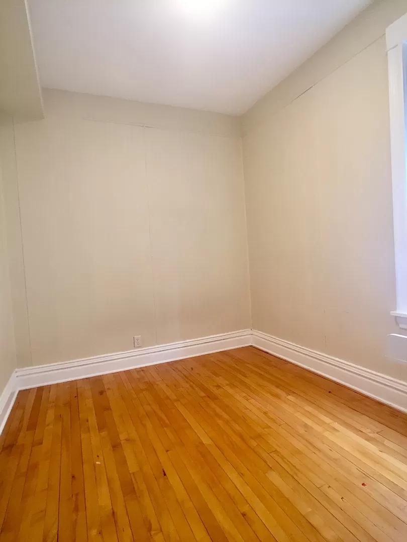 an empty room with wooden floors and white walls