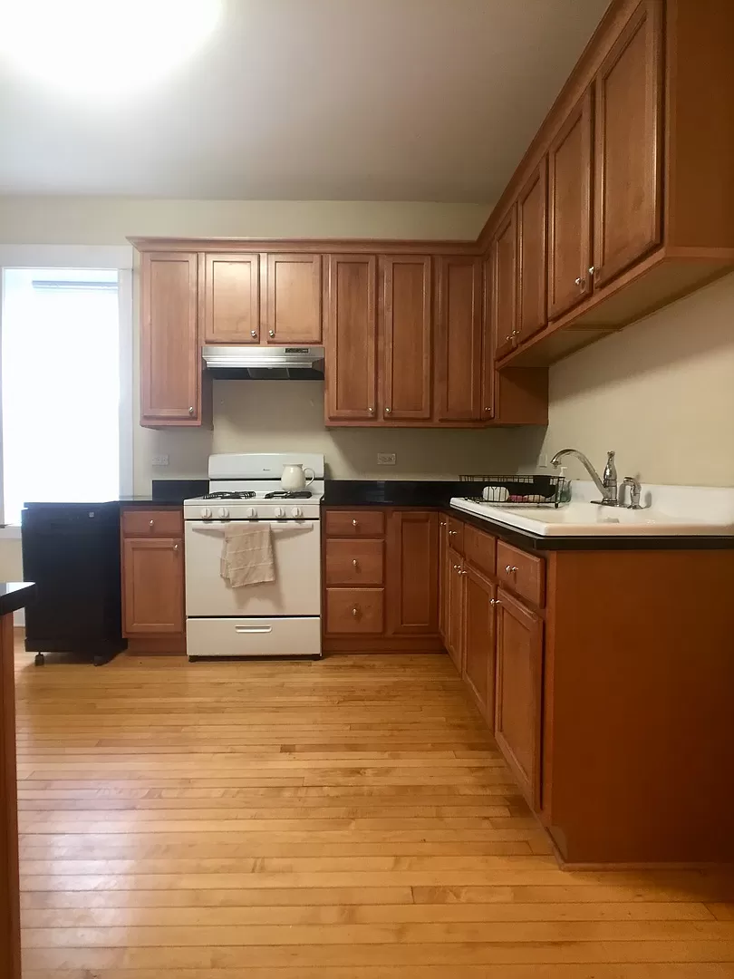 an empty kitchen with wooden floors and wooden cabinets