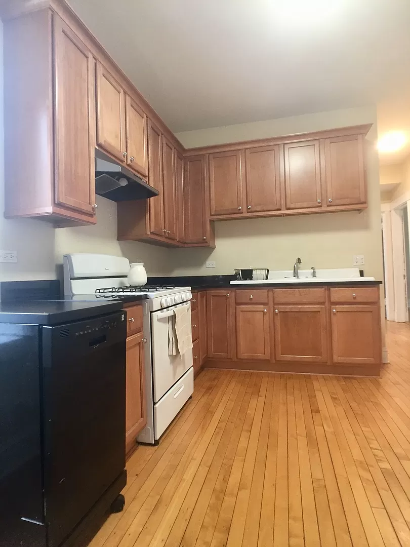 an empty kitchen with wooden floors and wooden cabinets