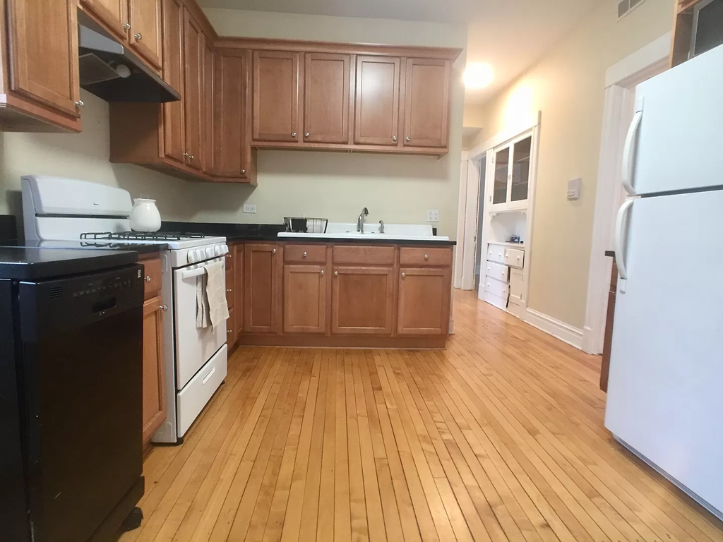 an empty kitchen with wooden floors and wooden cabinets